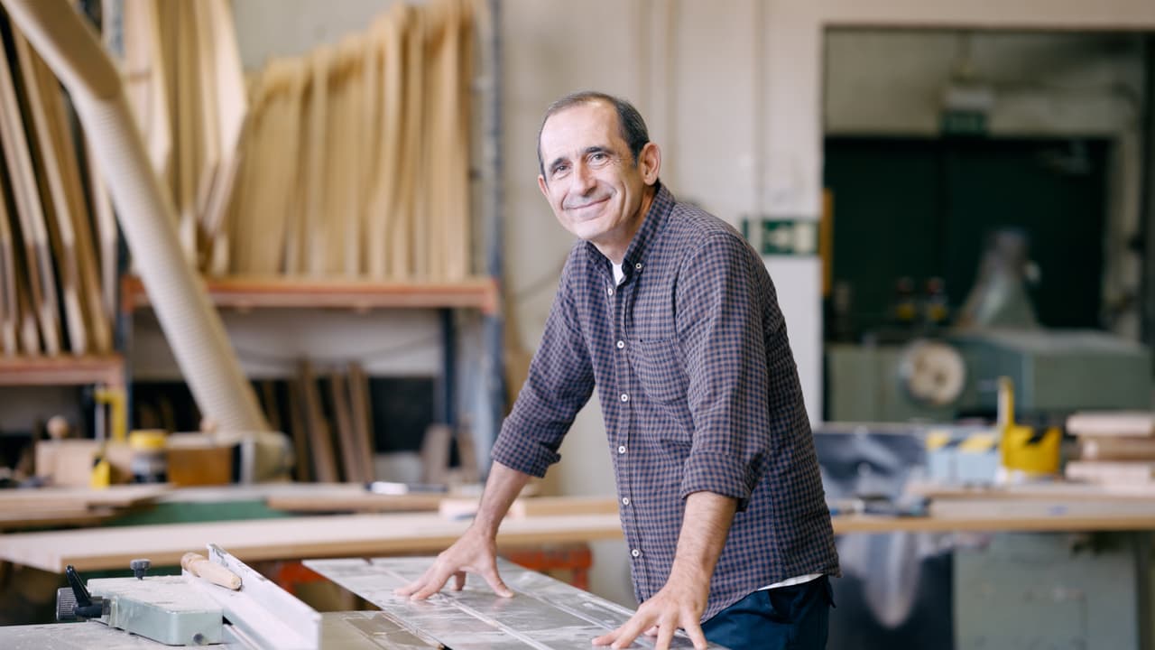 A joiner standing at a saw bench in his workshop